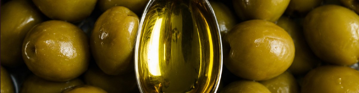 Aceitunas verdes y una cuchara de aceite de oliva virgen extra